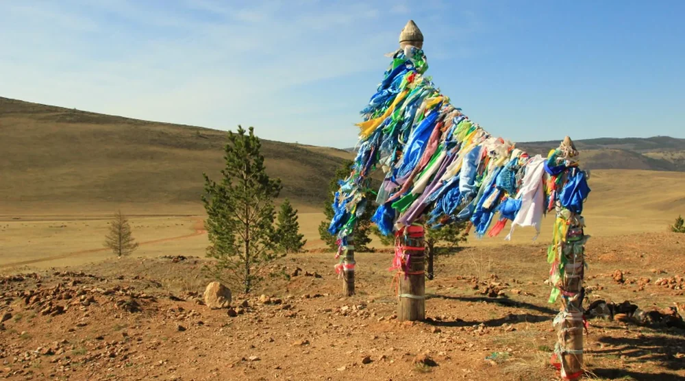 Traditional Buryat ritual poles decorated with colorful Hadak ribbons on Olkhon Island, Lake Baikal