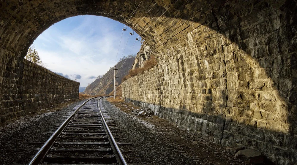 Railway tracks passing through a historic stone tunnel on the Circum-Baikal Railway