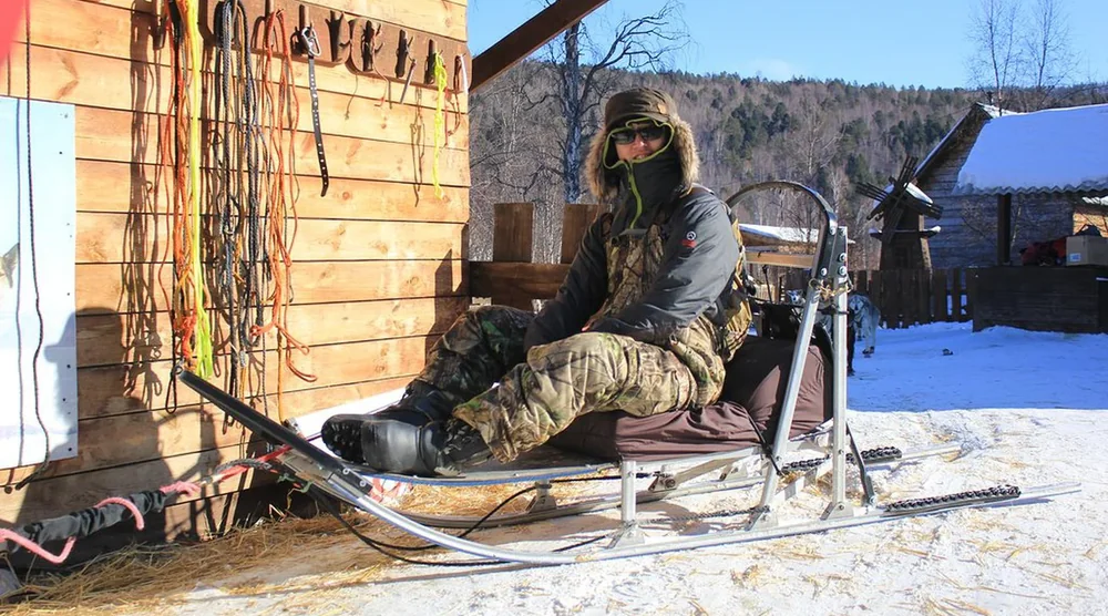 Person sitting on a dog sled prepared for a husky sledding tour at Lake Baikal