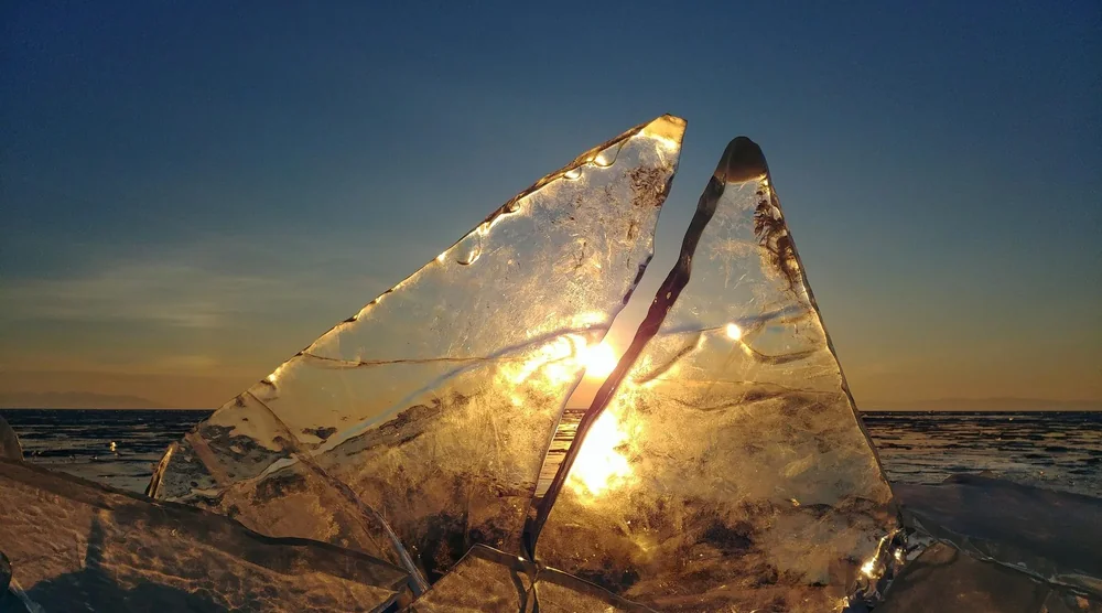 Crystal clear blue ice formations on Lake Baikal at sunset