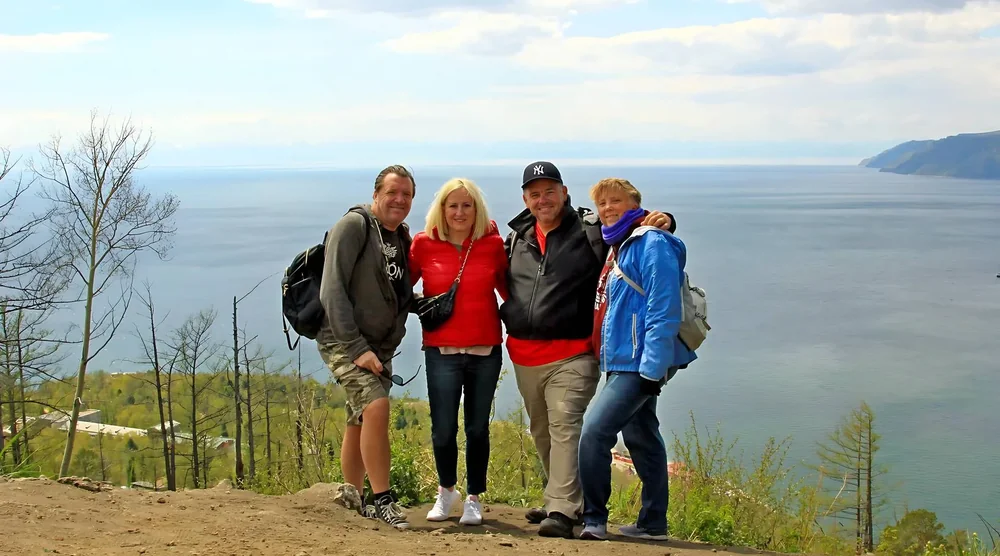 Group of tourists smiling during a summer tour near Lake Baikal in Listvyanka