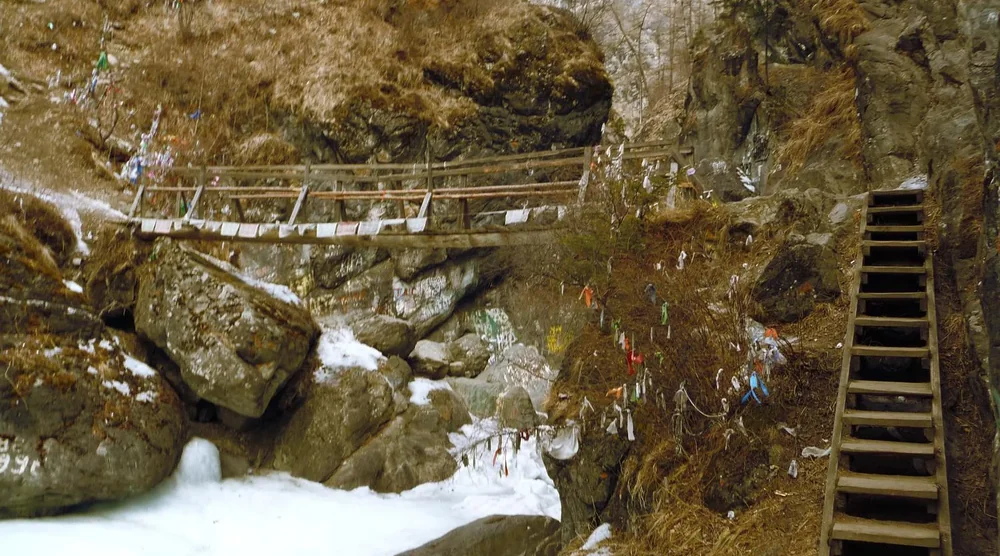 Wooden stairs and bridge with prayer flags in the mountains of Arshan Tunka Valley