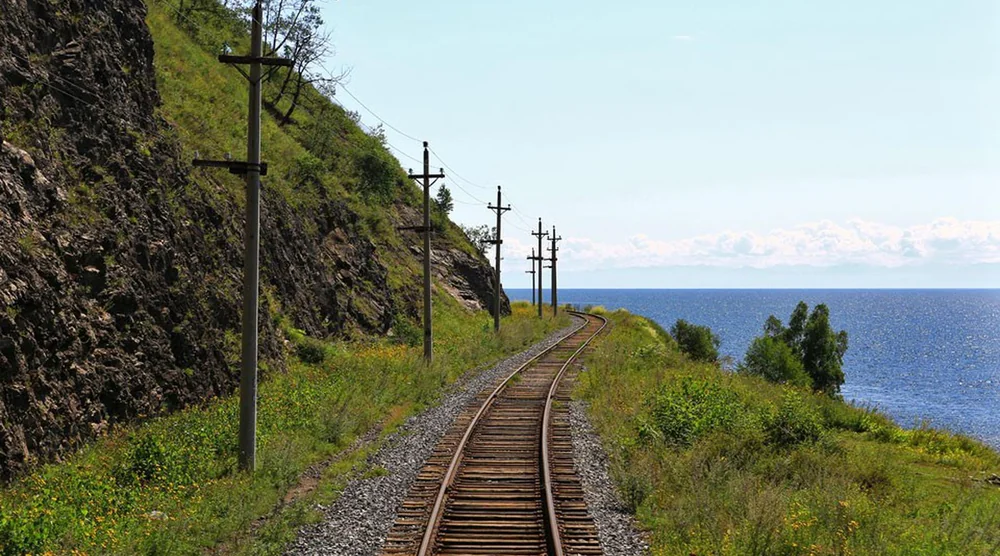Scenic view of the Circum-Baikal Railway tracks winding along the rocky coast of Lake Baikal