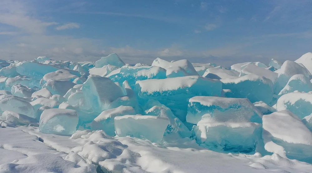 Large chunks of clear blue ice and snow on Lake Baikal during a winter tour